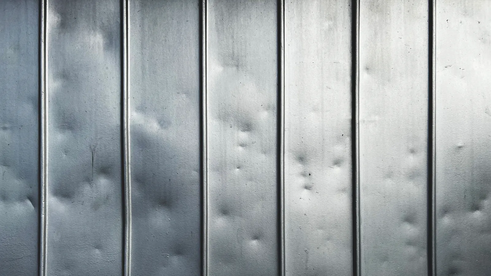 Scattered small dents covering ribbed sheet metal panels